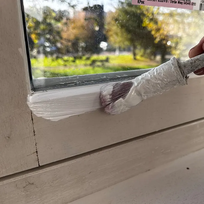 Kwast dichtbij bij het schilderen van een kozijn